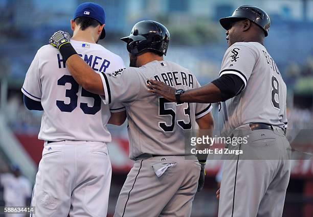 After hitting a single, Melky Cabrera of the Chicago White Sox talks with Eric Hosmer of the Kansas City Royals and first base coach Daryl Boston of...
