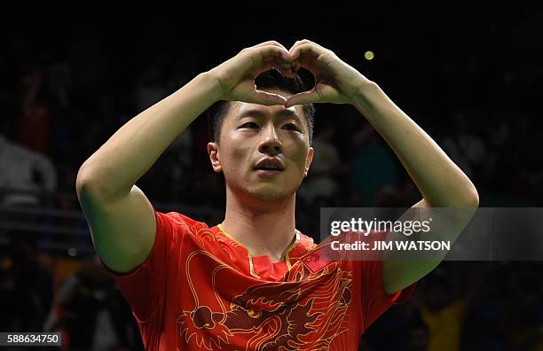 China's Ma Long celebrates beating China's Zhang Jike in their men's singles final gold medal table tennis match at the Riocentro venue during the...