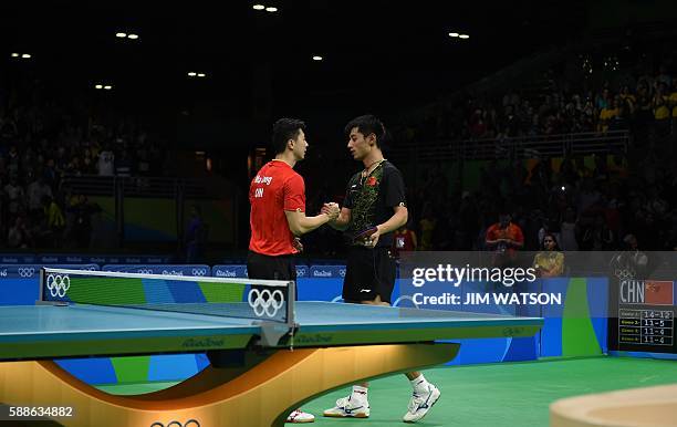 China's Ma Long greets China's Zhang Jike after winning their men's singles final gold medal table tennis match at the Riocentro venue during the Rio...