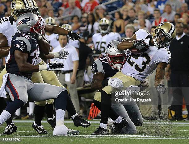 Marcus Murphy of the New Orleans Saints is stopped by Jordan Richards of the New England Patriots in the first half during a preseason game against...