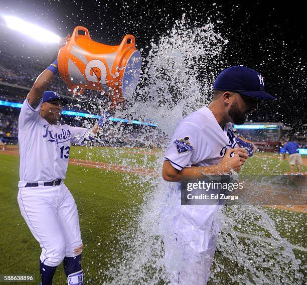 Starting pitcher Danny Duffy of the Kansas City Royals is doused with water by Salvador Perez after Duffy threw a complete game 2-1 win against the...