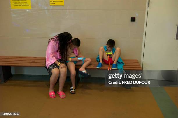 In this picture taken on July 25 kids look at their smartphones at an indoor playground in Chengdu in Sichuan province.