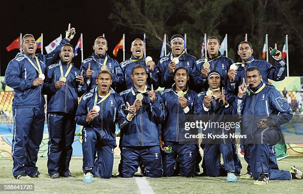 Fiji's players pose for photos with the gold medals they won in the men's rugby sevens tournament at the Rio de Janeiro Olympic Games on Aug. 11,...