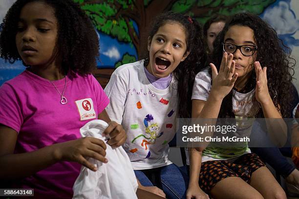 Julia Muniz from the Cantagalo 'favela' community reacts after being given a ticket to the Olympic Rugby 7's event on August 10, 2016 in Rio de...