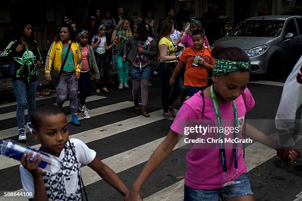 Children from the Cantagalo 'favela' community hold hands as they cross the street to the metro station on their way to the Olympic Rugby 7's on...