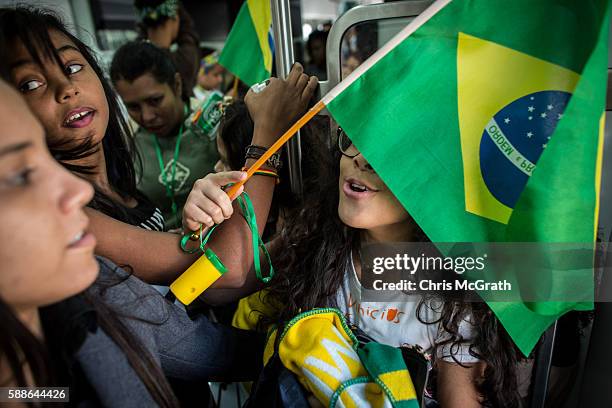 Julia Muniz from the Cantagalo "favela" community plays around with a Brazilian flag on the subway while travelling to the Olympic Rugby 7's on...