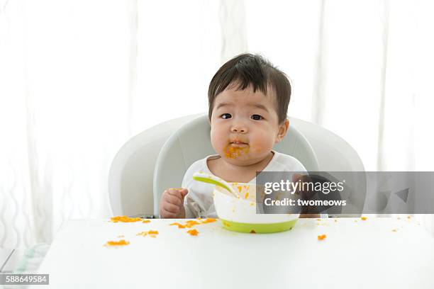 asian baby learning self feeding. - pure white background bildbanksfoton och bilder