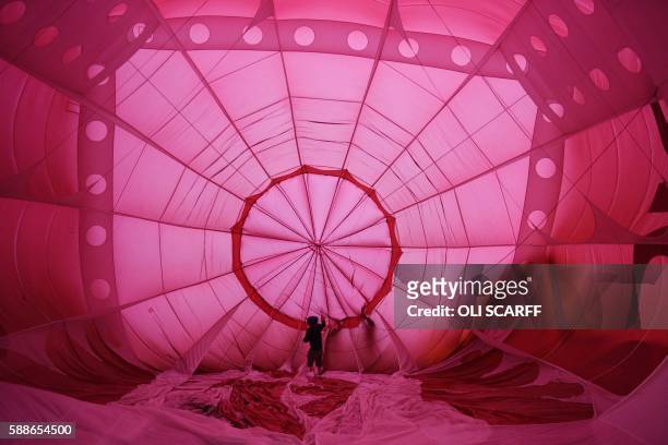 Balloonists prepare to inflate their hot air balloons on the second day of the Bristol International Balloon Fiesta in Bristol, southwest England, on...