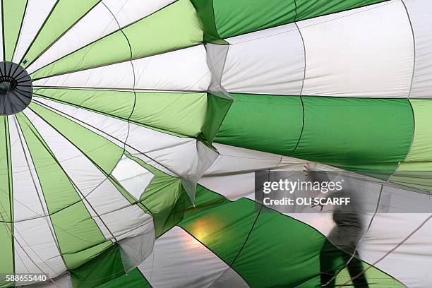 Balloonists inflate their hot air balloons on the second day of the Bristol International Balloon Fiesta in Bristol, southwest England, on August 12,...