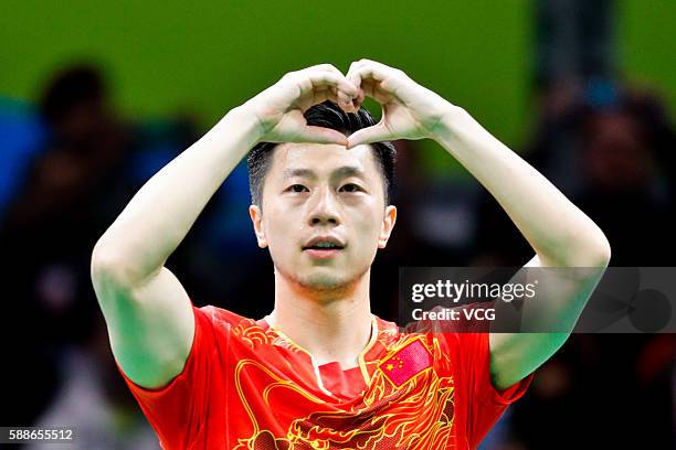 Ma Long of China makes the shape of a heart with his fingers after winning his match against Zhang Jike of China in Men's Singles Gold Medal Match on...