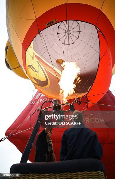 Balloonists inflate their hot air balloons on the second day of the Bristol International Balloon Fiesta in Bristol, southwest England, on August 12,...