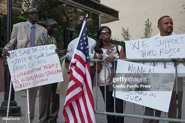 South Sudanese demonstrators hold signs while rallying in Dag Hammarskjold Plaza. On the same day that the United Nations Security Council held...