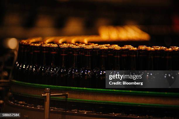 Unlabelled bottles of beer move along a conveyor belt on the production line at SABMiller Plc's Newlands brewery in Cape Town, South Africa, on...