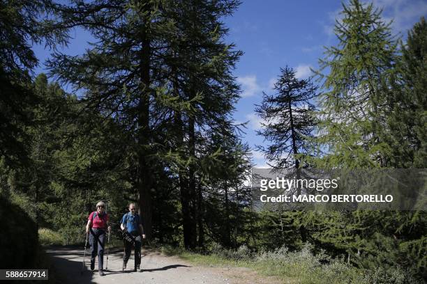 British Prime Minister Theresa May walks in a forest with her husband Philip at the start of a summer holiday in the Alps in Switzerland on August...