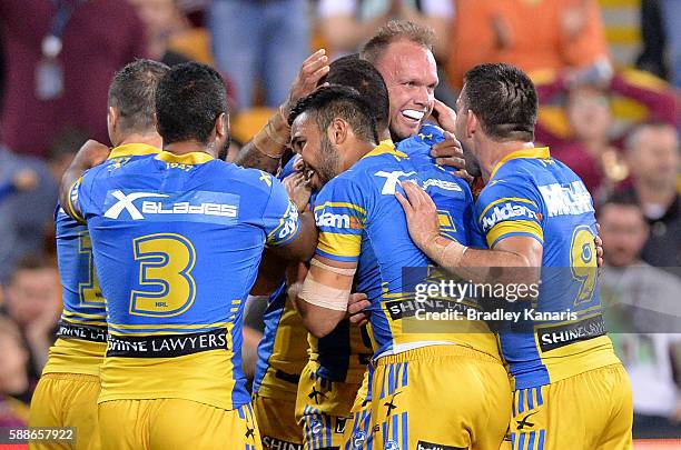 David Gower of the Eels is congratulated by team mates after scoring a try during the round 23 NRL match between the Brisbane Broncos and the...