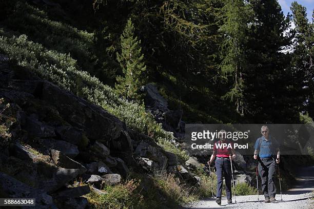 British Prime Minister Theresa May walks with her husband Philip John May while on summer holiday on August 12, 2016 in the Alps of Switzerland. The...