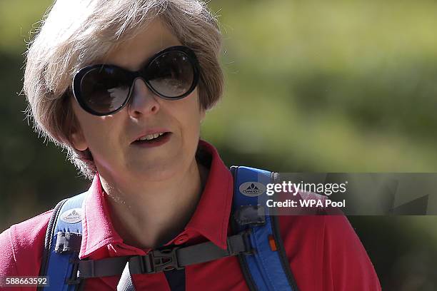 British Prime Minister Theresa May walks with her husband Philip John May while on summer holiday on August 12, 2016 in the Alps of Switzerland. The...