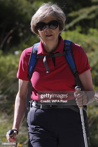 British Prime Minister Theresa May walks with her husband Philip John May while on summer holiday on August 12, 2016 in the Alps of Switzerland. The...