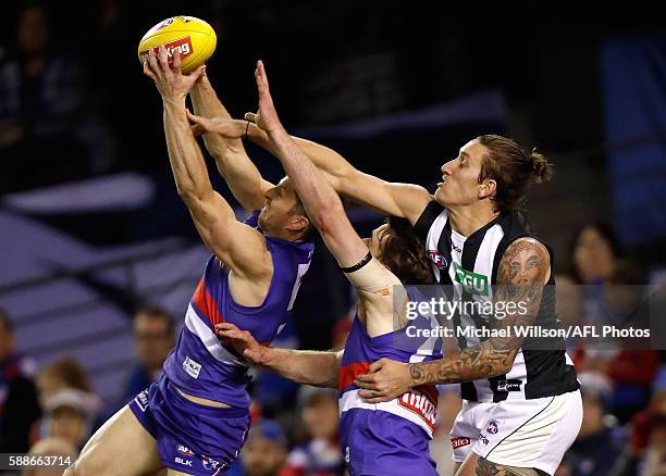 Matthew Boyd of the Bulldogs marks ahead of teammate Jordan Roughead and Jesse White of the Magpies during the 2016 AFL Round 21 match between the...