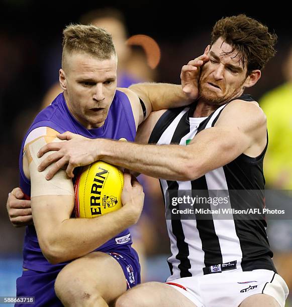 Jake Stringer of the Bulldogs fends off Tyson Goldsack of the Magpies during the 2016 AFL Round 21 match between the Western Bulldogs and the...