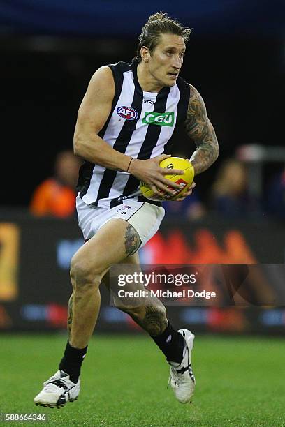 Jesse White of the Magpies runs with the ball during the round 21 AFL match between the Western Bulldogs and the Collingwood Magpies at Etihad...