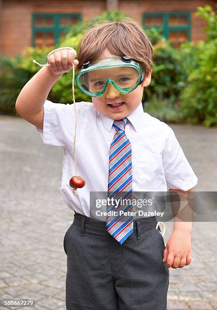 school boy playing conkers - horse chestnut imagens e fotografias de stock