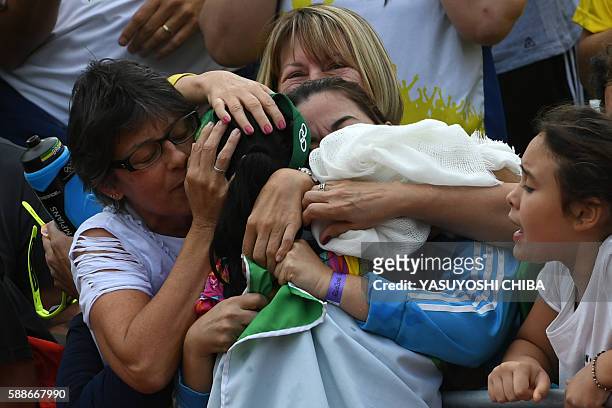Brazil's Agatha Bednarczuk hugs women in the crowd as she celebrates after winning, with teammate Brazil's Barbara Seixas De Freitas, their women's...