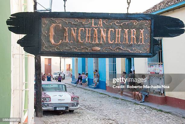 La Canchanchara Sign and general view of cobblestone street in Trinidad. La Canchanchara is a popular bar in the village serving a traditional drink...