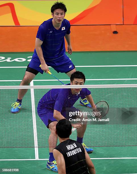 Kenichi Hayakawa and Hiroyuki Endo Of Japan compete against Hendra Setiawan and Mohammad Ahsan of Indonesia in the badminton Men's Doubles Group Play...