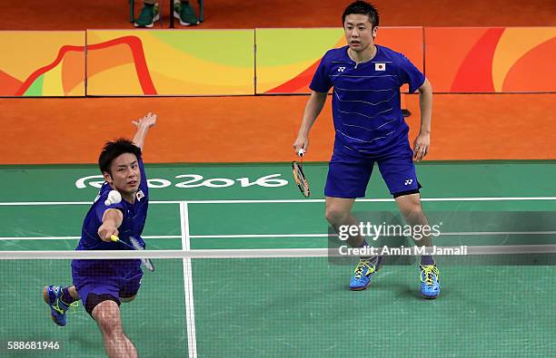 Kenichi Hayakawa and Hiroyuki Endo Of Japan compete against Hendra Setiawan and Mohammad Ahsan of Indonesia in the badminton Men's Doubles Group Play...