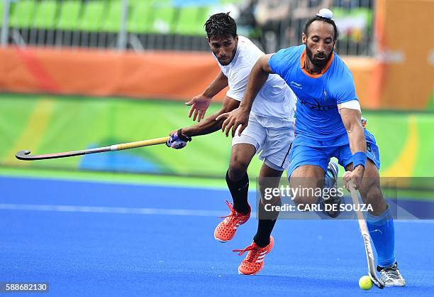 Canada's David Carter and India's Sardar Singh vie during the mens's field hockey India vs Canada match of the Rio 2016 Olympics Games at the Olympic...