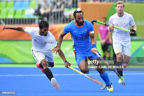 Canada's David Carter and India's Sardar Singh vie during the mens's field hockey India vs Canada match of the Rio 2016 Olympics Games at the Olympic...