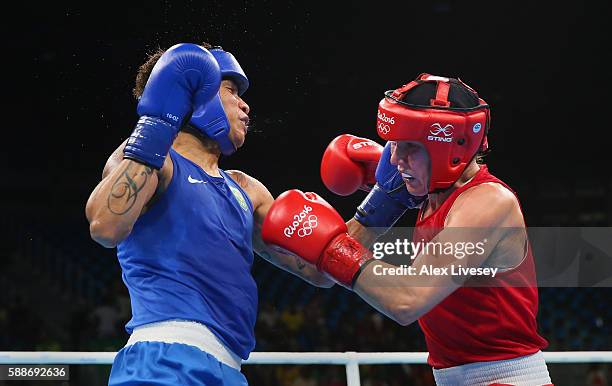 Mira Potkonen of Finland and Adriana Araujo of Brazil trade punches during the Women's Lightweight Preliminaries bout on Day 7 of the 2016 Rio...