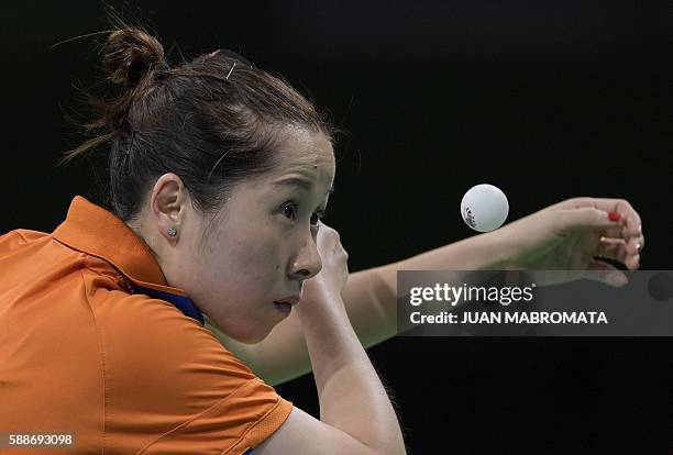 Netherlands' Li Jie eyes the ball as she serves in the women's team qualification round table tennis match against Austria at the Riocentro venue...