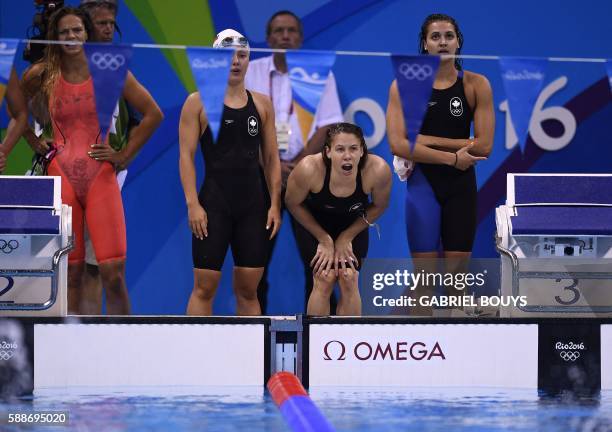 Team Canada with Kelly Masse, Rachel Nicol and Noemie Thomas cheer at teammate Taylor Ruck next to Russia's Yulia Efimova during the Women's 4x100m...