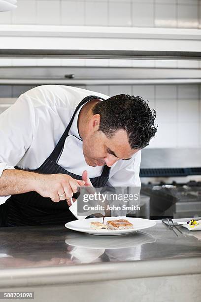 male chef preparing meal in kitchen - pouring sauce stock pictures, royalty-free photos & images