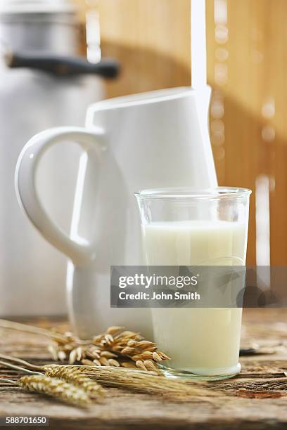 glass of milk next to pitcher - milk pitcher ストックフォトと画像