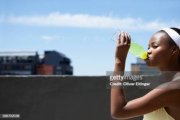 woman drinking sports drink - oliver eltinger stock-fotos und bilder