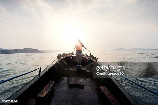 visitors ride a boat put out to sea. - asian fishing boat stock-fotos und bilder