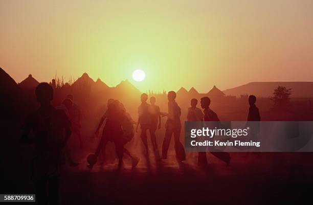 playing soocer at sunset - somalië stockfoto's en -beelden