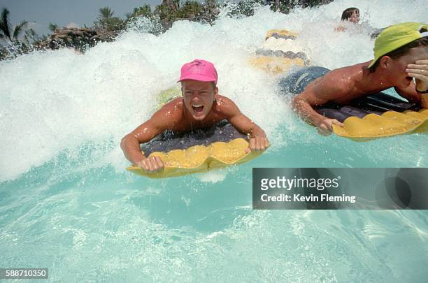 youngsters riding waves at typhoon lagoon - typhoon lagoon stock pictures, royalty-free photos & images