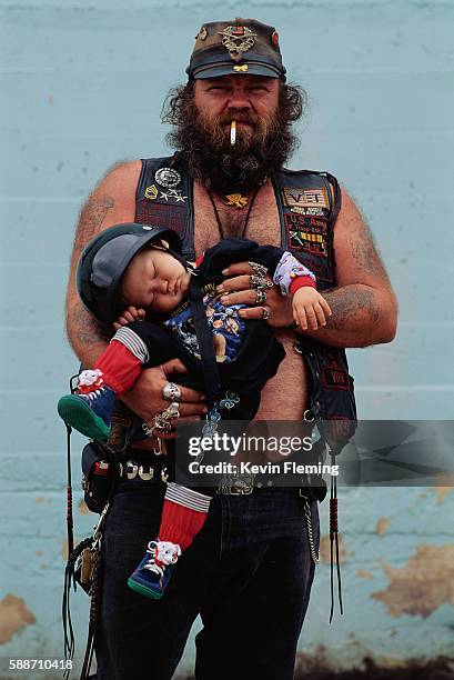 biker father holding sleeping son - leather vest stock pictures, royalty-free photos & images