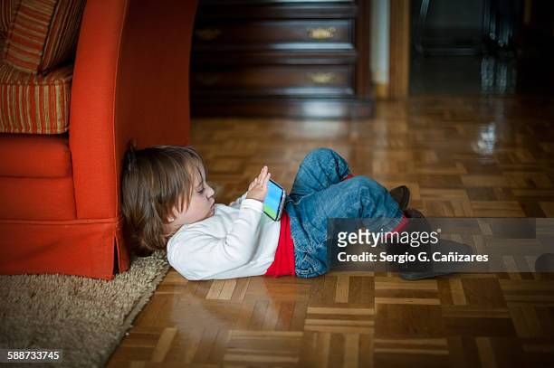 little girl plays with smartphone at home - child mobile phone stock-fotos und bilder