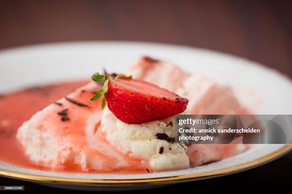 Bavarois with strawberry on white plate.
