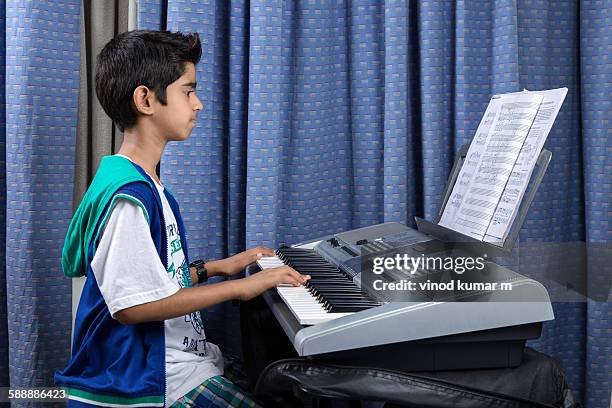 young boy playing keyboard side view - keyboard musical instrument child stock pictures, royalty-free photos & images