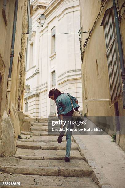 stylish woman standing on one leg in the street - montpellier stockfoto's en -beelden