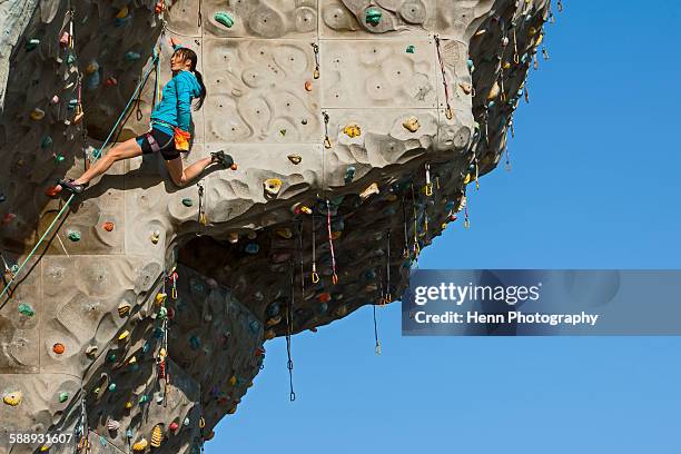 woman climbing on artificial climbing wall in seoul - climbing wall stock pictures, royalty-free photos & images