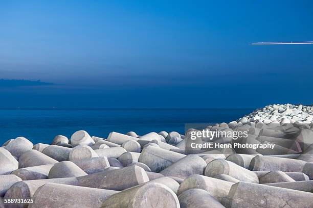 concrete flood defenses in jetju si on jeju island - groyne stock-fotos und bilder