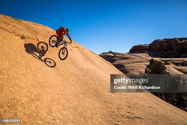 man jumping his mountain bike on slickrock.  - moab utah fotografías e imágenes de stock