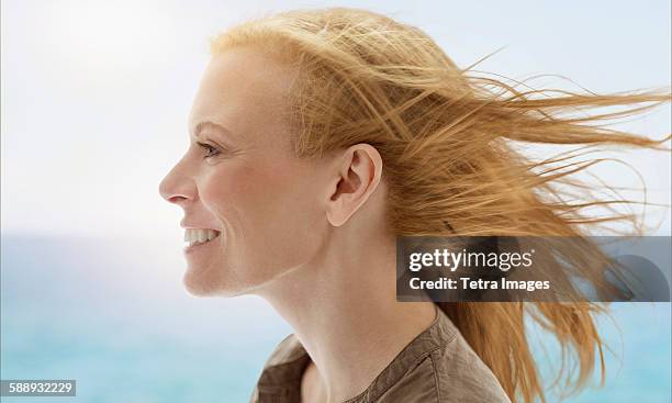 portrait of woman by sea - schulterlanges haar stock-fotos und bilder